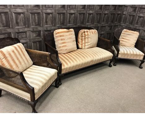 EDWARDIAN MAHOGANY FRAMED BERGERE SUITEcomprising a two-seater sofa and two armchairs, single-caned, upholstered in striped p