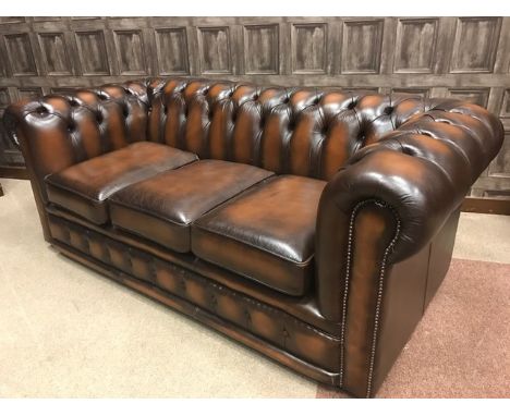 TAN LEATHER SUITE IN CHESTERFIELD MANNERcomprising a three-seat button-back settee and two winged button-backed and studded a