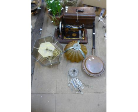 A vintage Jones sewing machine, two light shades and a copper warming pan 