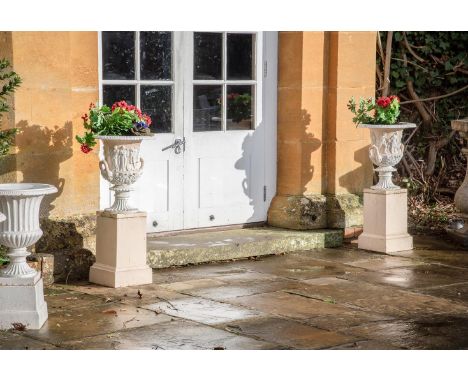 A PAIR OF PAINTED CAST IRON MEDICI URNS ON BASES  19TH CENTURY Painted in pale ochre and white each 87cm high overall, bases 