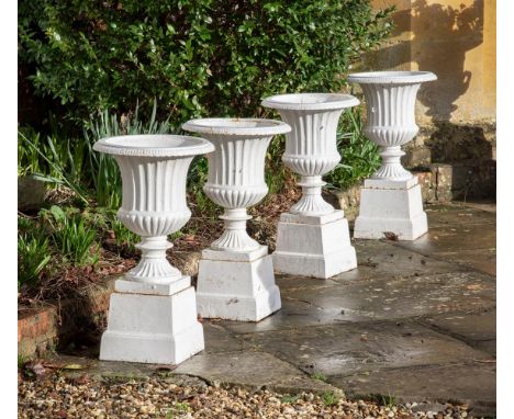 A SET OF FOUR CAST IRON CAMPANA URNS ON STANDS  19TH CENTURY  White painted fluted urns and bases  68cm high overall, bases 2