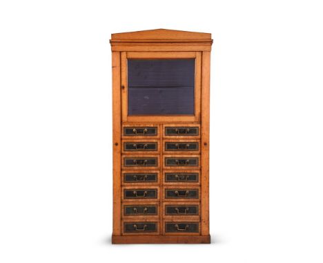 AN UNUSUAL VICTORIAN OAK COMBINED CUPBOARD AND CHEST OF 'WELLINGTON' TYPE, LATE 19TH CENTURY The panelled door opening to an 