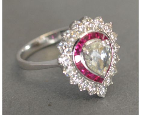 An 18ct. White Gold Pear Cut Diamond and Ruby Ring, with a central diamond surrounded by rubies and diamonds within a pierced