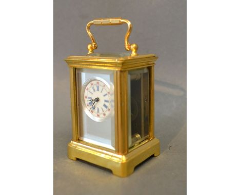 A Brass Cased Miniature Carriage Clock, the silver face with circular enamel dial and carrying handle, with visible lever esc