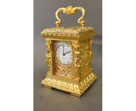 A Miniature Brass Cased Carriage Clock, the case decorated in relief with figures and foliage and with carrying handle and vi