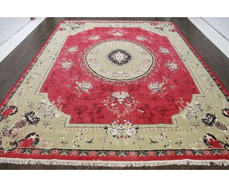 A North West Persian Woollen Carpet with a central medallion within an all over design upon a red and cream ground within mul