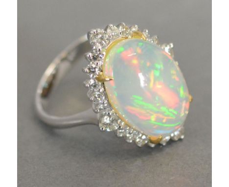 An 18ct. White Gold Opal and Diamond Ring, with an oval cabochon opal surrounded by diamonds, opal 3.46 ct, diamonds 0.62 ct