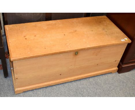 A Victorian pine trunk, with hinged lid and enclosing a candle box, on moulded base with bracket feet, 116cm by 50cm by 46cm