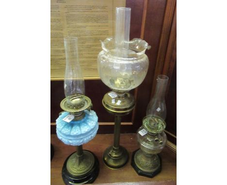 Three early 20th Century double oil lamps, one with a blue opaline glass moulded floral and foliate reservoir. All standing o