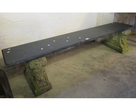 Garden bench having weathered composition stands on a slate slab seat.(B.P. 21% + VAT) 