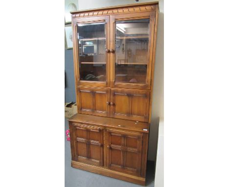 Elm Ercol two stage kitchen cabinet on a projecting base with two blind panelled doors, with gold Ercol sticker. 98 x 50 x 19