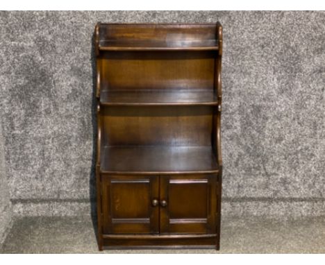 Dark Ercol waterfall bookcase with below cupboards, 61x34cm, height 110cm