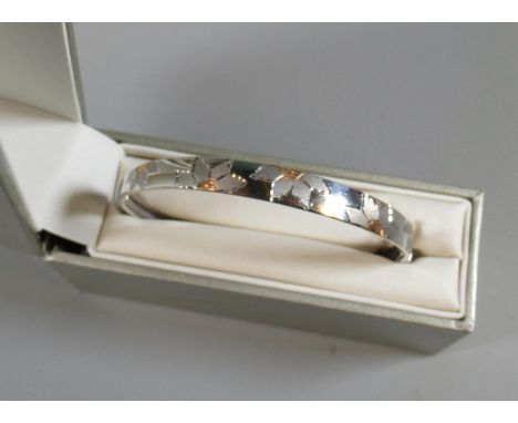 9ct white gold bangle engraved with flowers. Approx weight 5.7 grams. (B.P. 21% + VAT)Condition is good. No obvious damage. I
