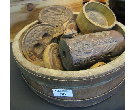 Rustic coopered wooden bowl with metal banding containing various butter moulds and stamps of different designs; animals, fru
