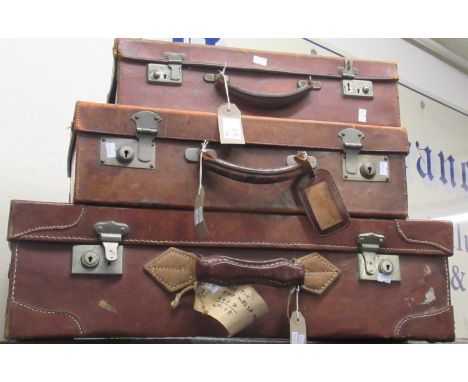 Three vintage tan leather suitcases, each with carrying handles and metal locks and clasps. Provenance Margaret Bide Collecti