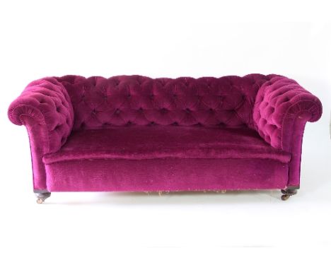 A two-seater button back Chesterfield sofa with mahogany turned front legs, upholstered in violet velvet 