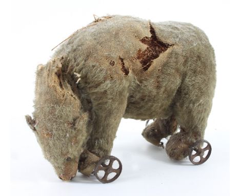 A Steiff polar bear, circa 1915, on four metal spoke wheels, 24cm high, 30cm long Condition Report: The growling and moving h