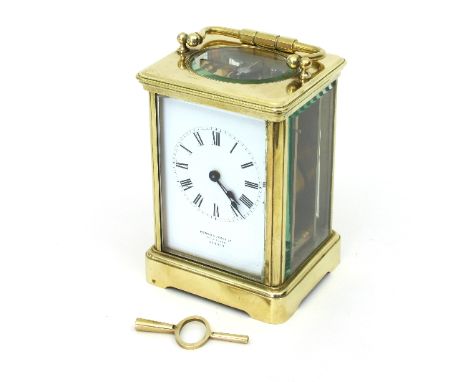 A gilt brass cased carriage clock, the enamel dial with Roman numerals and retailers mark for Howell & James Ltd., To The Que