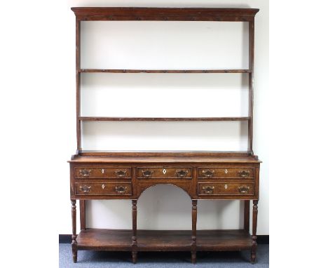 A late 18th Century oak dresser, the open rack on a five-drawer base with turned legs united by a platform stretcher, 157cm w