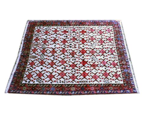 A PERSIAN CARPET, cream ground with stylised red ground medallions. 8ft 2ins x 6ft 6ins.