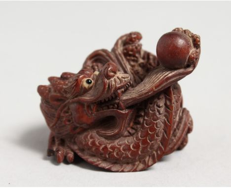 A CARVED JAPANESE WOODEN DRAGON NETSUKE. 1.75ins.