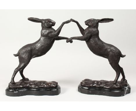 A PAIR OF BRONZE BOXING HARES on shaped marble bases. 11.5ins high.