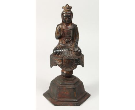 A BRONZE FIGURE OF BUDDHA on a pedestal, one open palm facing forward. 11ins high.