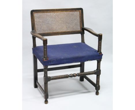 A BEECH FRAMED BOBBIN TURNED ARMCHAIR, with cane work back and upholstered seat.