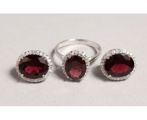 A SILVER AND GARNET RING and MATCHING EARRINGS.