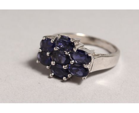 A SILVER SEVEN STONE SAPPHIRE RING.