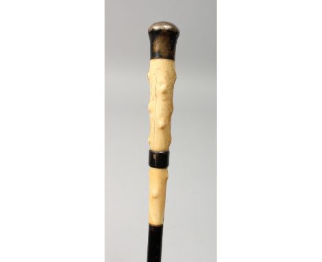 A VICTORIAN BONE HANDLED CANE with silver band and top. 33ins long.