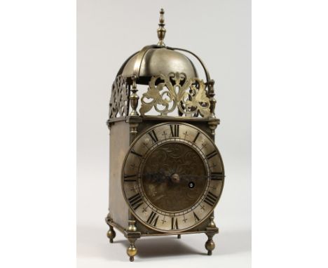 AN 18TH CENTURY BRASS LANTERN CLOCK of typical form, with bell, silvered chapter ring and engraved back-plate. 14.5ins high.