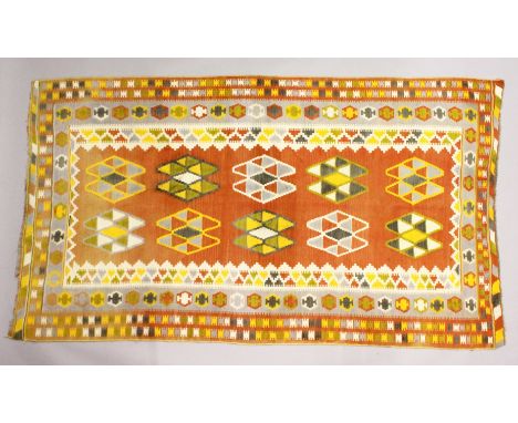 A PERSIAN KELIM CARPET, orange ground with typical geometric decoration. 7ft 9ins x 4ft 5ins.