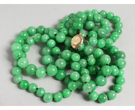 A DOUBLE ROW OF ONE HUNDRED AND TWENTY JADE BEADS with gold clasp.