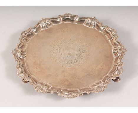 A GEORGE II SILVER PIECRUST SALVER with cast border and crest on three hoof feet. 11ins diameter. London 1757. Weight 26ozs.