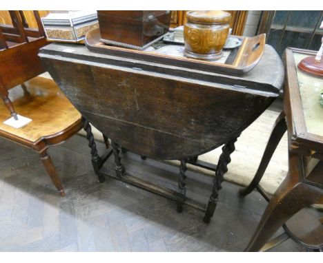 An oval oak gate legged table on barley twist legs, 2'6 wide 