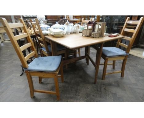 A modern pine drop leaf dining table and four ladder back style chairs with blue seat pads 