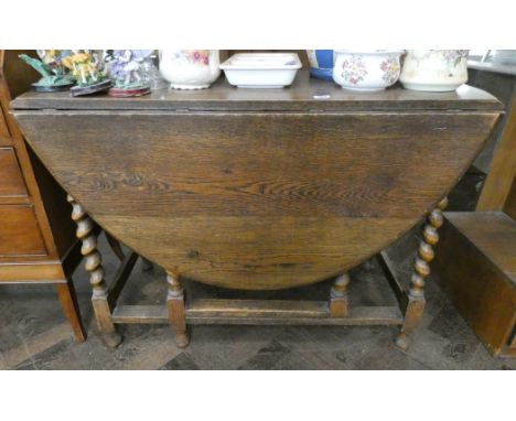 An oval oak gate legged table on barley twist legs, 3'6 wide 