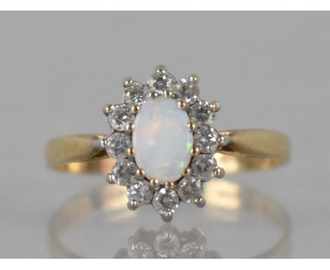 A 9ct Gold, Opal and CZ Ladies Dress Ring, Prong Set Central Oval Cabochon Plaque 6mm by 4mm with a Halo of Small Round Brill