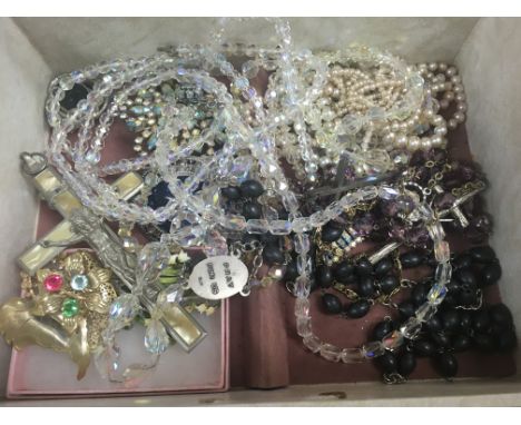 A box of costume jewellery including two tie pins .