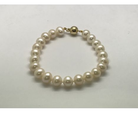 A white cultured pearl strung necklace with a 9ct yellow gold ball clasp.