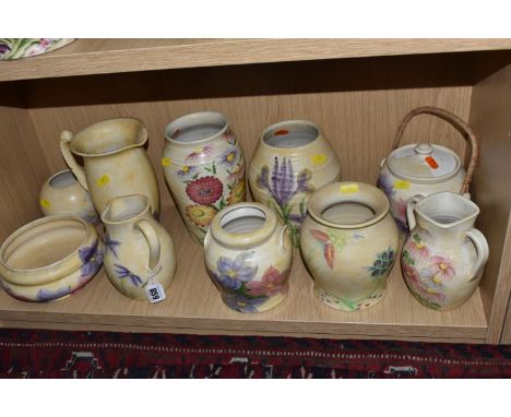 A COLLECTION OF NINE YELLOW FLORAL E RADFORD ITEMS comprising a yellow lidded vase with a wicker handle (loss of paintwork to