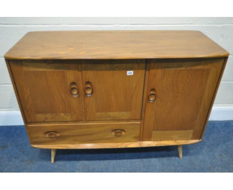 LUCIAN ERCOLANI, ERCOL, A MID CENTURY ELM AND BEECH SIDEBOARD, fitted with three cupboard doors and a single drawer, raised o
