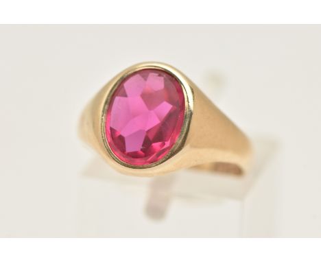 A 9CT GOLD RUBY SIGNET RING, of an oval form set with a polished ruby assessed as synthetic, collet set to a polished band, h