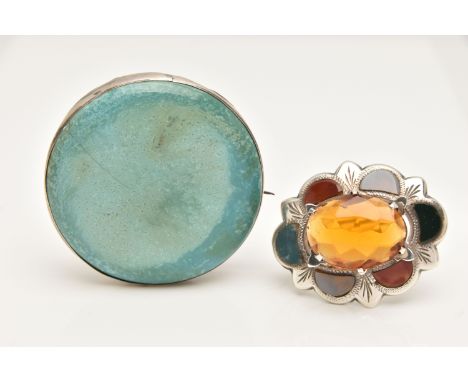 A CERAMIC 'RUSKIN' BROOCH AND SCOTTISH HARDSTONE BROOCH, a circular form brooch with white metal mount, fitted with a pin and