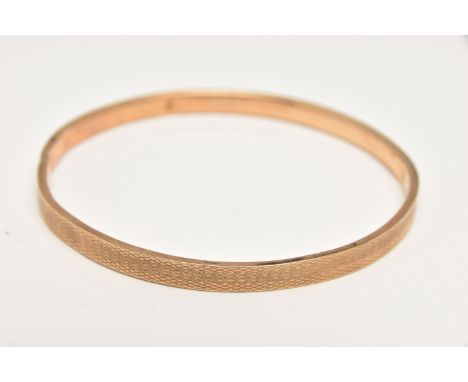AN EARLY 20TH CENTURY, 9CT GOLD ENGINE TURNED PATTERN BANGLE, approximate band width 5.3mm, hallmarked 9ct Birmingham 1924, a