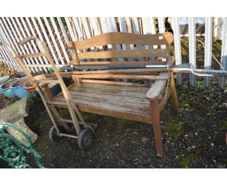 A MODERN HARDWOOD GARDEN BENCH, with slatted seat and back, width 127cm, along with four gardening tools and a sack truck (6)