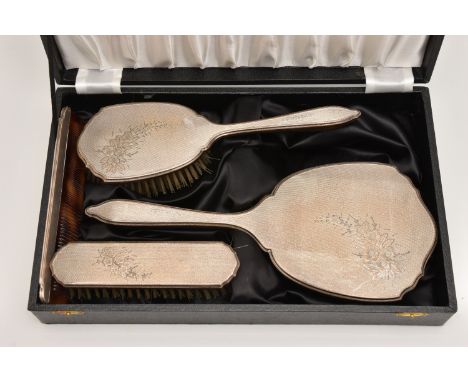 A CASED SILVER FOUR PIECE VANITY SET, comprising of a hand held mirror, hair brush, clothes brush and comb, all with a floral