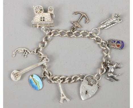 A silver charm bracelet including enamel charms and a heart shaped clasp. 