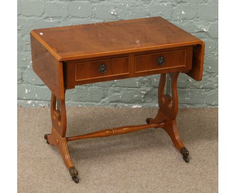 A yew wood two drawer sofa table raised on twin lyre supports.